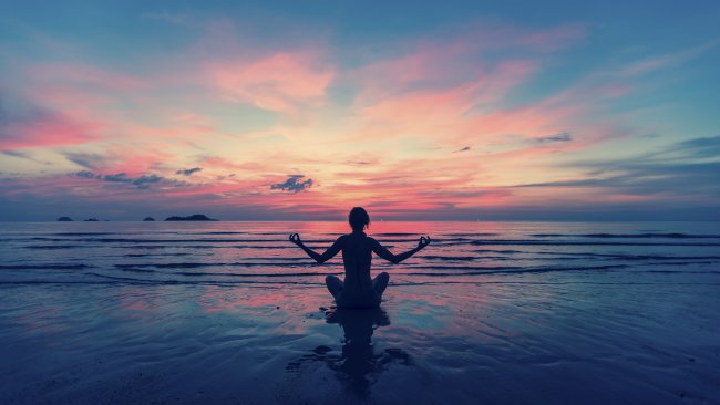 לנשום ולהצליח - Woman doing meditation near the ocean beach